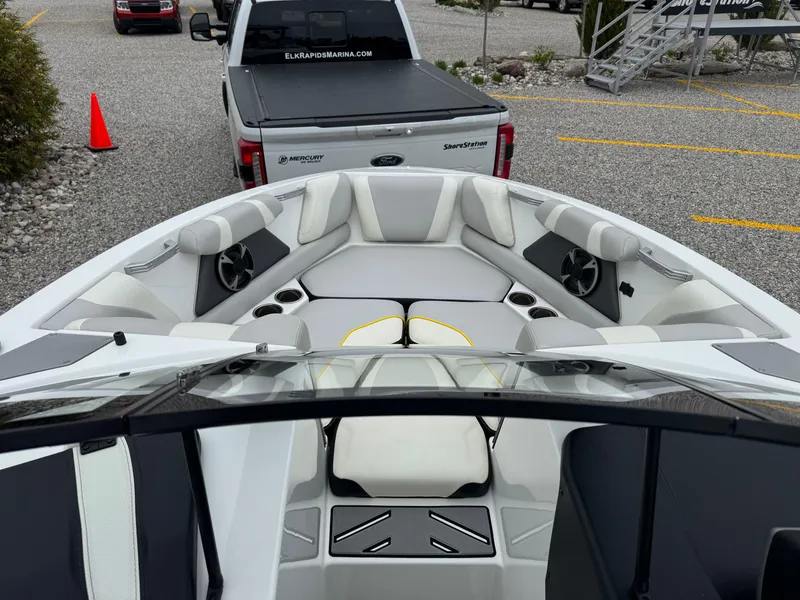 Slide: The Image of 2018 Malibu VLX boat interior with seating, parked near a Ford truck. - 10