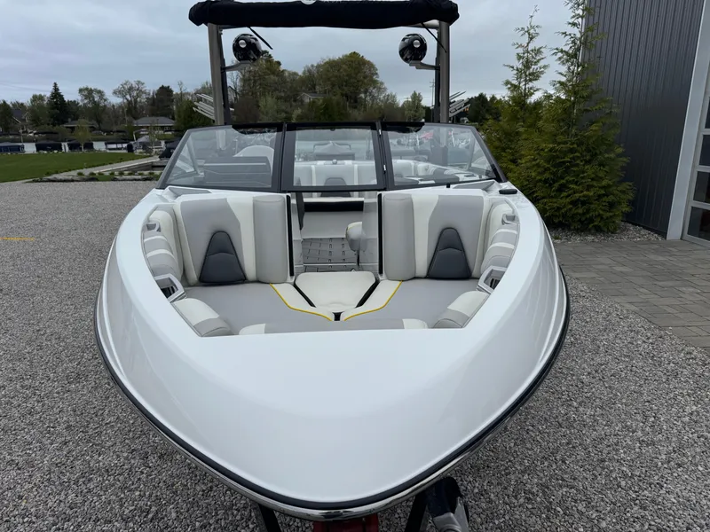 Slide: The Image of 2018 Malibu VLX boat with sleek design and spacious seating, parked outdoors. - 3