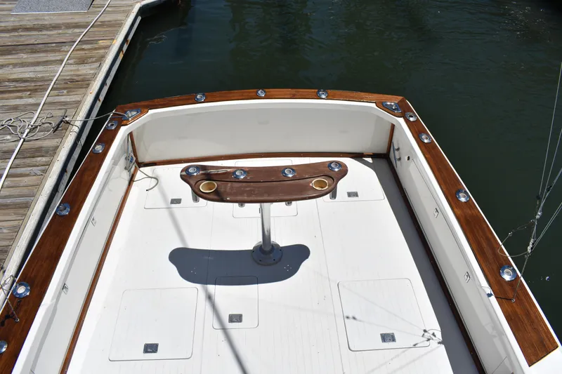 Slide: The Image of 1965 Bertram 31 boat deck with wooden trim and fishing rod holders. - 10