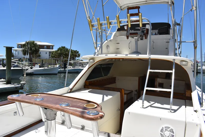Slide: The Image of 1965 Bertram 31 yacht with fishing setup, docked in a marina under clear blue skies. - 13