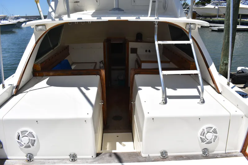 Slide: The Image of 1965 Bertram 31 boat interior with open cabin and ladder, docked at marina. - 14
