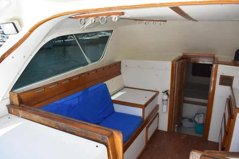 Slide: The Image of Interior of a 1965 Bertram 31 boat with blue seating and wooden accents. - 15