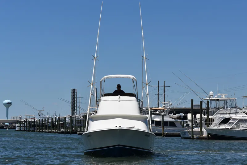 Slide: The Image of 1965 Bertram 31 boat docked at marina under clear blue sky. - 3