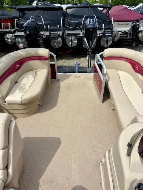 Slide: The Image of 2011 Bennington 20SLi pontoon boat with beige and red seating, docked near other boats. - 10