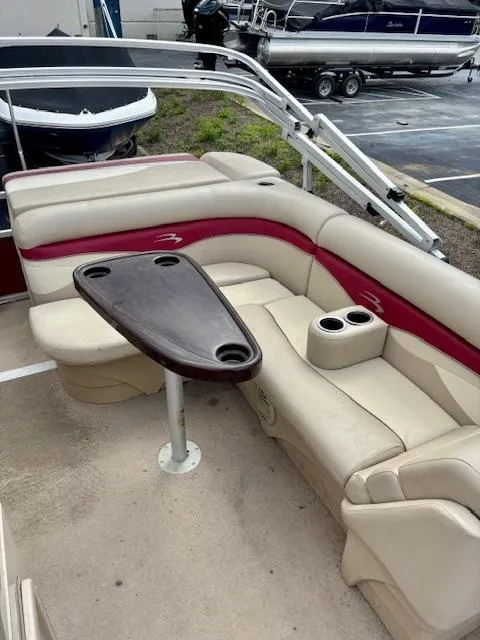 Slide: The Image of 2011 Bennington 20SLi boat interior with beige and red seating, table, and cup holders. - 7