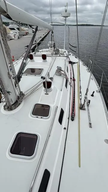 Slide: The Image of 2003 J Boats J/46 sailboat deck with hatches, docked by the water. - 10