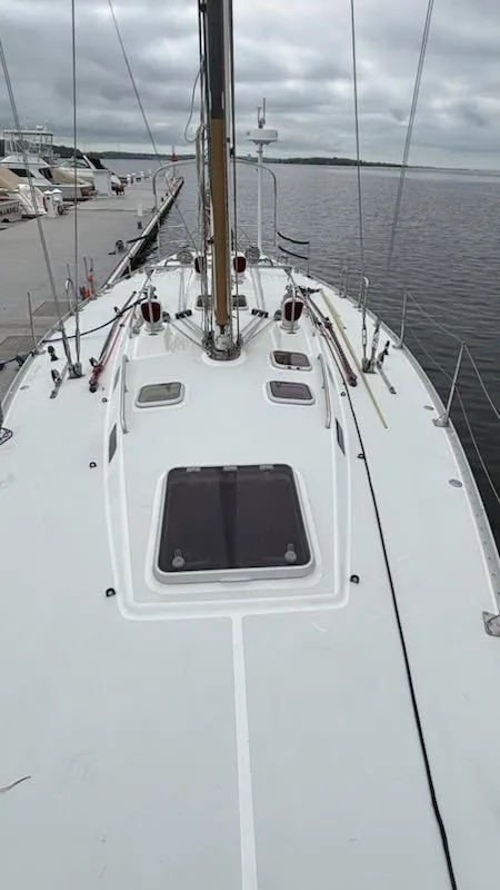 Slide: The Image of 2003 J Boats J/46 sailboat docked, showcasing deck and mast under cloudy skies. - 11