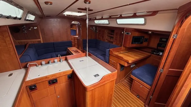 Slide: The Image of 2003 J Boats J/46 yacht interior with wood finish and blue seating. - 30