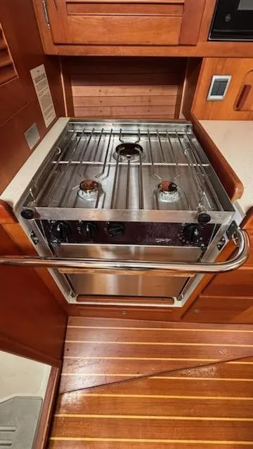 Slide: The Image of 2003 J Boats J/46 yacht kitchen with stainless steel stove and wooden cabinetry. - 33