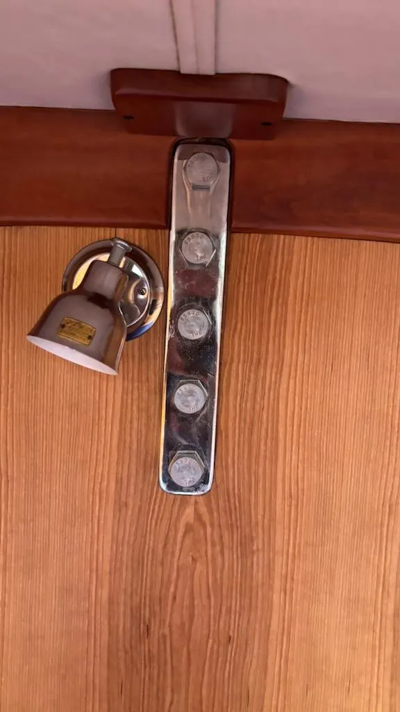 Slide: The Image of Interior detail of a 2003 J Boats J/46, featuring a wooden panel and metal fixture. - 42