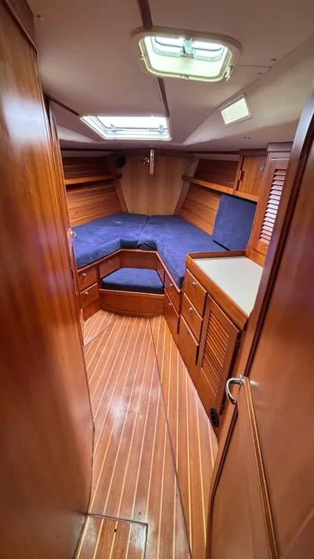 Slide: The Image of 2003 J Boats J/46 cabin interior with wood finish and blue cushions. - 43