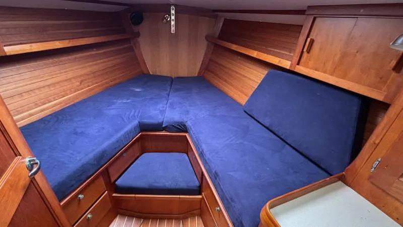 Slide: The Image of 2003 J Boats J/46 cabin interior with blue cushions and wooden finish. - 44
