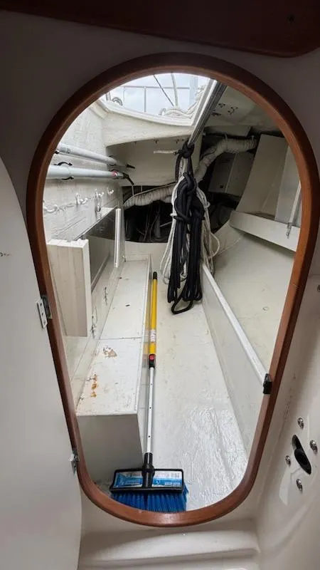 Slide: The Image of Interior view of 2003 J Boats J/46 sailboat, showing storage area and cleaning tools. - 48