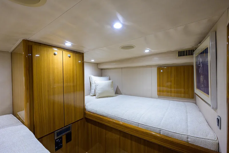 Slide: The Image of 2013 Viking 42 Open cabin interior with wooden cabinetry and cozy bedding. - 19