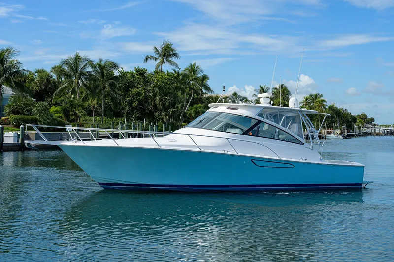 Slide: The Image of 2013 Viking 42 Open yacht on calm water with palm trees in the background. - 28
