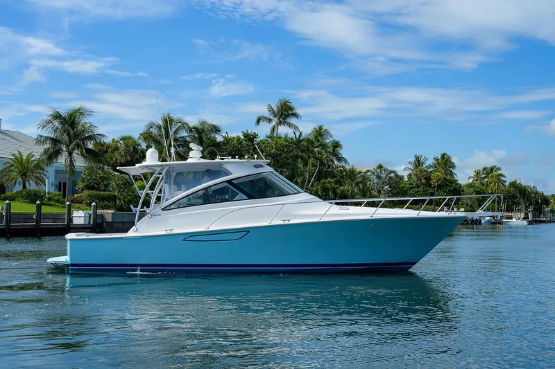 Slide: The Image of 2013 Viking 42 Open yacht on calm water, surrounded by palm trees and blue sky. - 30