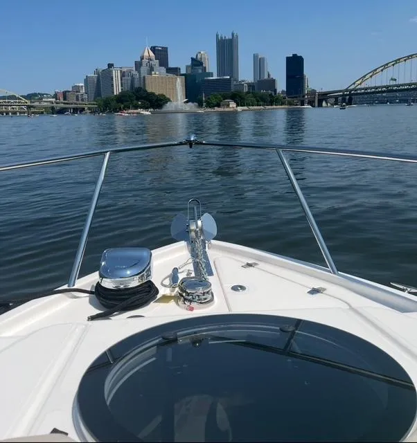 Slide: The Image of 2024 Regal 26 X boat cruising towards city skyline on a sunny day. - 13