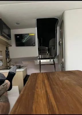 Slide: The Image of Interior of 2024 Regal 26 X boat with wooden table and modern amenities. - 8