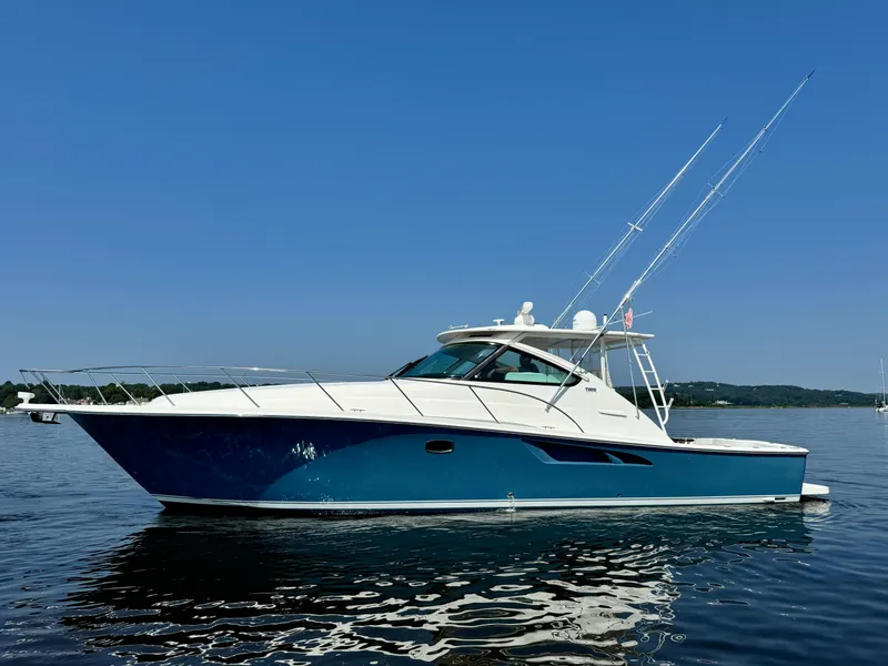 Slide: The Image of 2019 Tiara Yachts 4300 Open, sleek design, cruising on calm waters under clear blue sky. - 1
