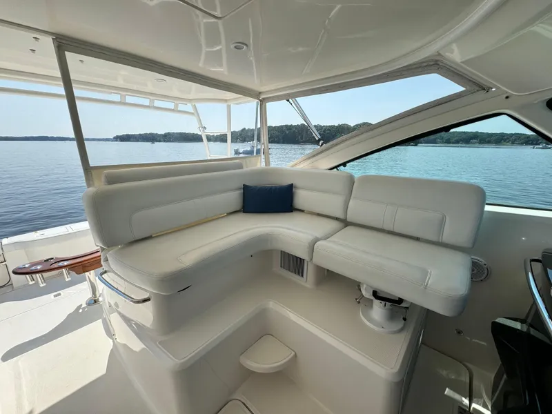 Slide: The Image of 2019 Tiara Yachts 4300 Open interior with white seating, overlooking serene water. - 12
