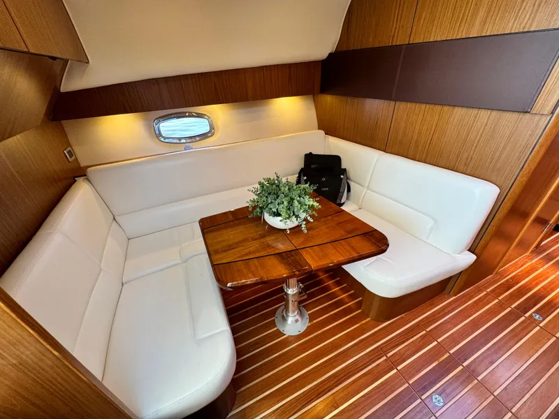Slide: The Image of 2019 Tiara Yachts 4300 Open interior with elegant wood and white seating. - 20