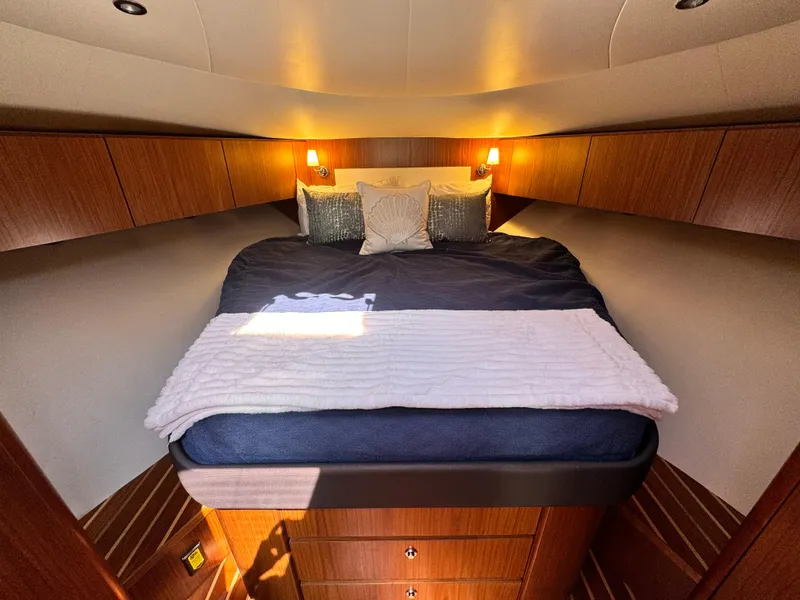 Slide: The Image of Luxurious cabin interior of 2019 Tiara Yachts 4300 Open with cozy bedding and warm lighting. - 27
