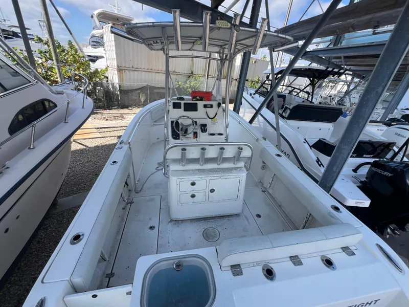 Slide: The Image of 2023 Cobia 237 Center Console boat in storage, featuring spacious deck and modern controls. - 11