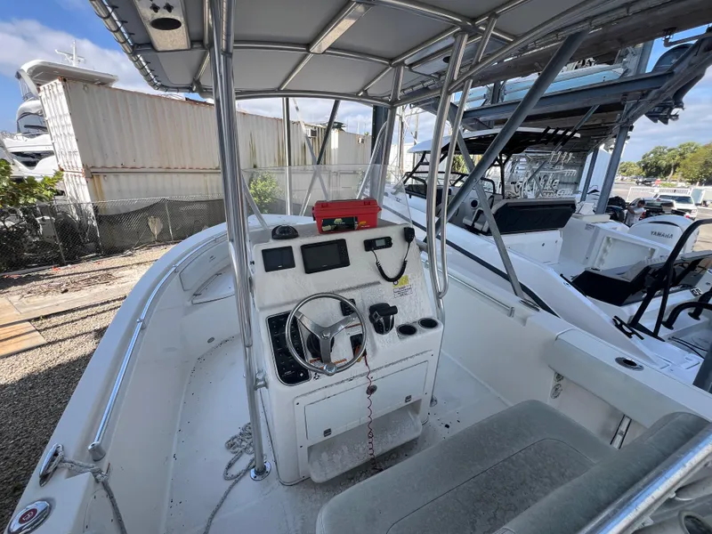 Slide: The Image of 2023 Cobia 237 Center Console boat interior with steering wheel and navigation equipment. - 12