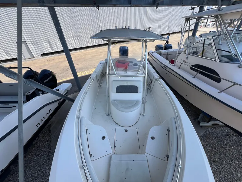 Slide: The Image of 2023 Cobia 237 Center Console boat docked, featuring spacious deck and modern design. - 2