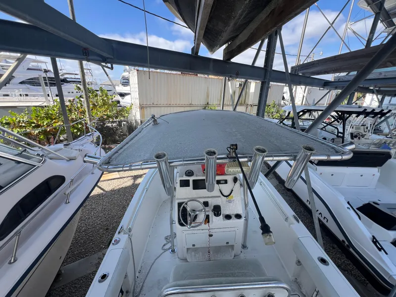 Slide: The Image of 2023 Cobia 237 Center Console boat in storage, featuring a covered helm and rod holders. - 4