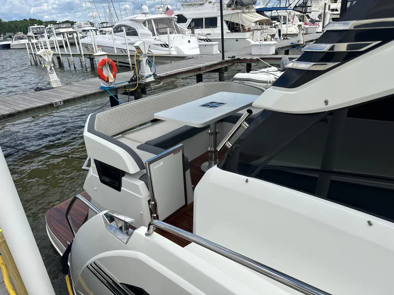 Slide: The Image of 2021 Galeon 425 HTS yacht docked at marina, featuring sleek design and outdoor seating area. - 15