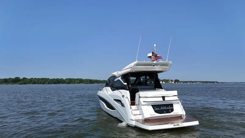 Slide: The Image of 2021 Galeon 425 HTS yacht cruising on a calm lake under a clear blue sky. - 2