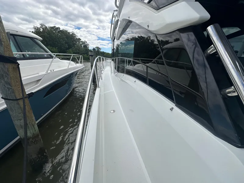 Slide: The Image of 2021 Galeon 425 HTS yacht docked beside another boat on a cloudy day. - 23