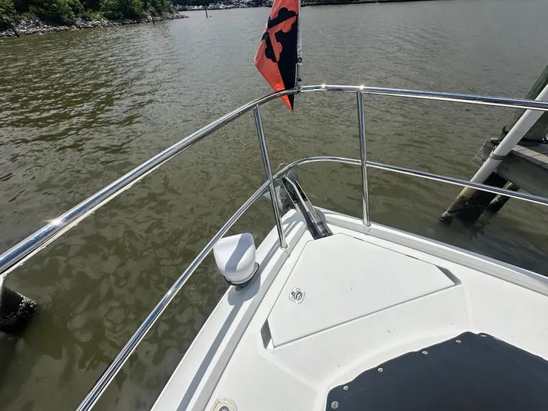 Slide: The Image of Bow of 2021 Galeon 425 HTS yacht with railing and flag on calm water. - 44