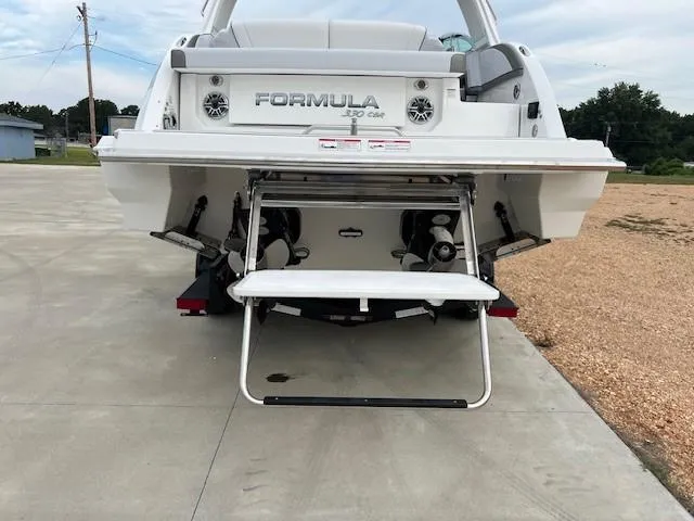 Slide: The Image of 2025 Formula 330 Crossover Bowrider I/O, rear view with swim platform and ladder. - 13