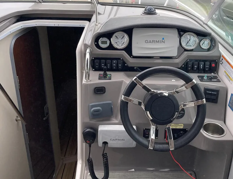 Slide: The Image of 2015 Regal 28 Express boat cockpit with Garmin navigation system and steering wheel. - 10