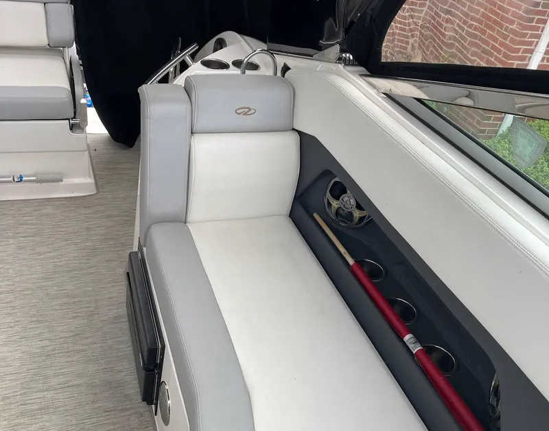 Slide: The Image of Interior of a 2015 Regal 28 Express boat with white seating and storage compartments. - 12