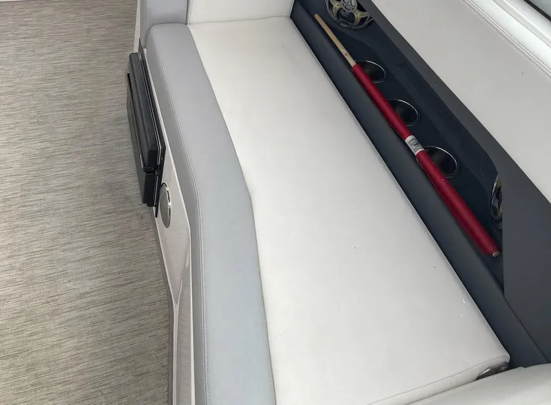 Slide: The Image of 2015 Regal 28 Express boat interior with white seating and rod holders. - 13