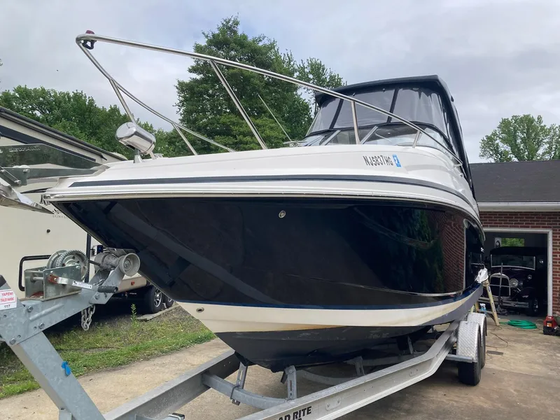 Slide: The Image of 2015 Regal 28 Express boat on trailer, parked outdoors near garage. - 3