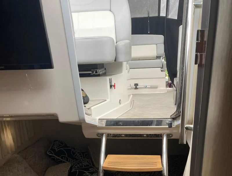 Slide: The Image of Interior view of a 2015 Regal 28 Express boat, featuring seating and a ladder. - 4