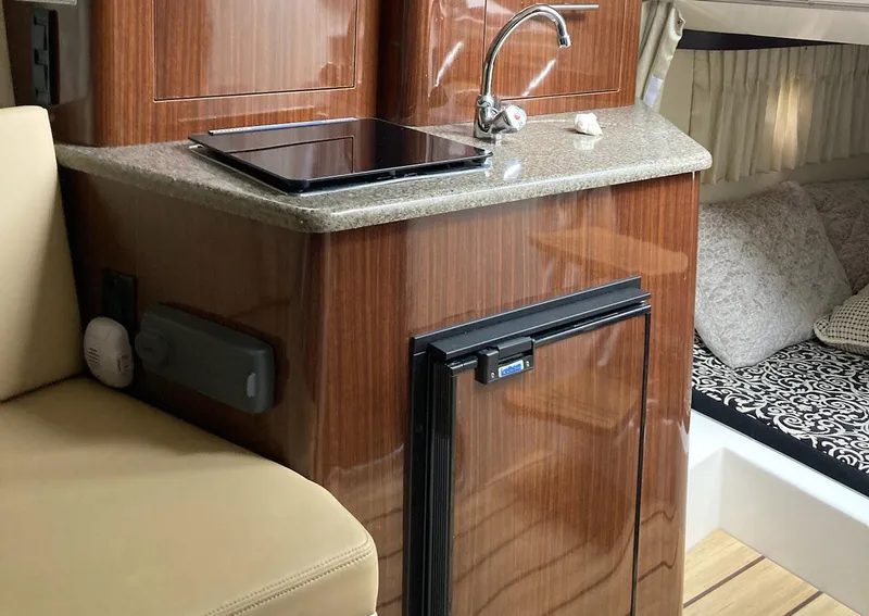 Slide: The Image of Interior of 2015 Regal 28 Express boat with kitchenette and seating area. - 8