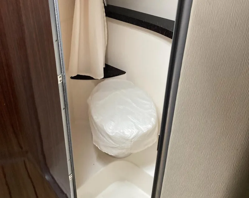 Slide: The Image of Compact bathroom in 2015 Regal 28 Express boat with covered toilet. - 9