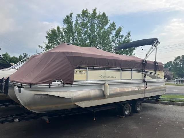 The Image of 2007 Bennington 2275QXi pontoon boat with cover on trailer, parked outdoors. - 0