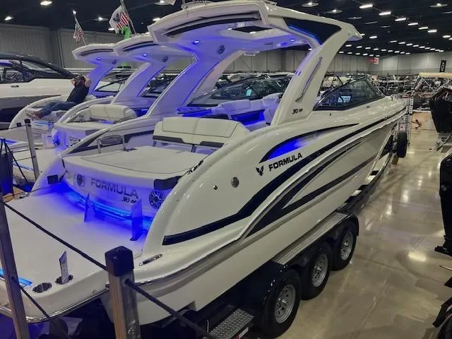 Slide: The Image of 2025 Formula 310 Bowrider I/O boat displayed indoors with blue LED lighting. - 18