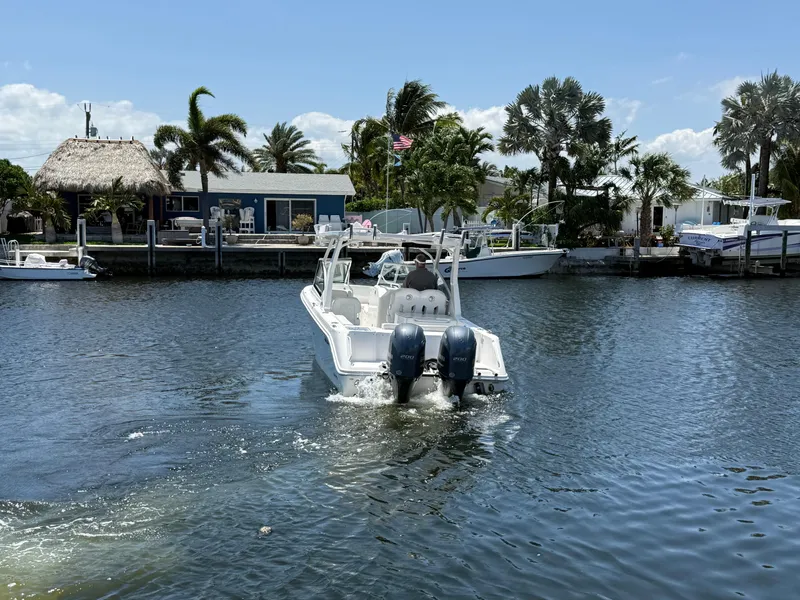 Slide: The Image of 2022 Edgewater 262 CX boat cruising on a sunny day near a waterfront property. - 12