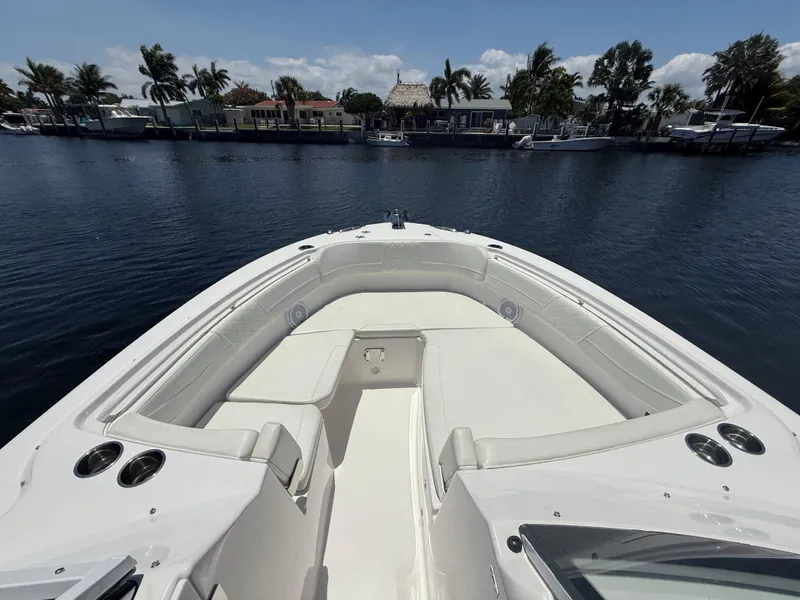 Slide: The Image of 2022 Edgewater 262 CX boat with spacious seating, docked by a scenic waterfront. - 13