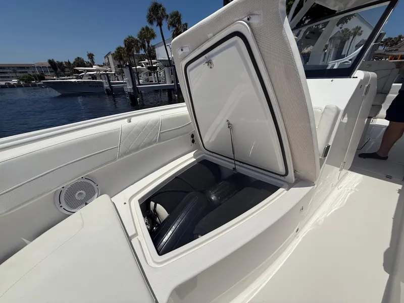 Slide: The Image of 2022 Edgewater 262 CX boat with open storage compartment, dockside view. - 16