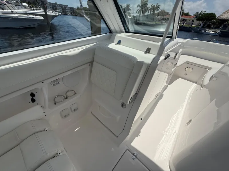 Slide: The Image of 2022 Edgewater 262 CX boat interior with white seating and waterfront view. - 20