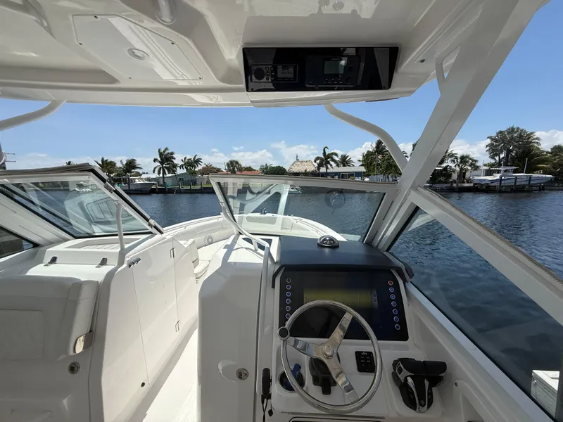 Slide: The Image of Interior view of 2022 Edgewater 262 CX boat with steering wheel and dashboard. - 22