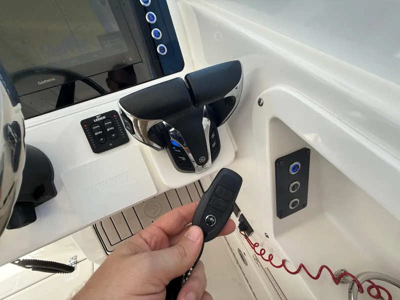 Slide: The Image of Control panel of 2022 Edgewater 262 CX boat with throttle and key fob. - 26